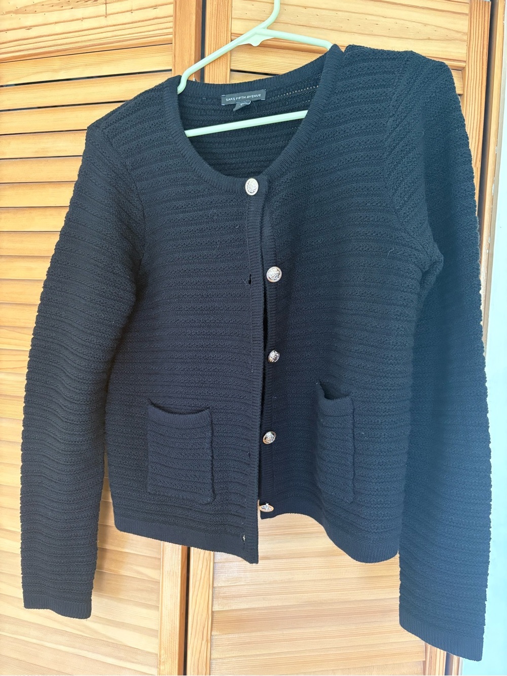 Black Saks Fifth Avenues knit cardigan sweater with metallic colored buttons.